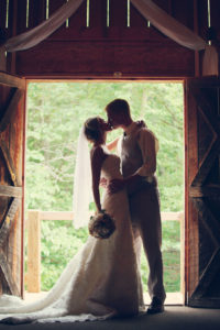 rustic wedding couple kissing in barn wedding venue