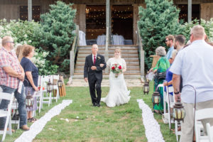 bride walking down the aisle at barn wedding